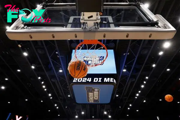 General view of a March Madness basketball falling through the net during NCAA Tournament First Four Practice at UD Arena.