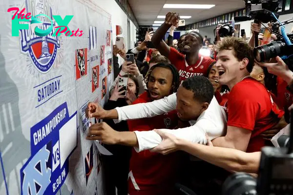 North Carolina State Wolfpack guard KJ Keatts (13) places the team sticker on the tournament bracket.