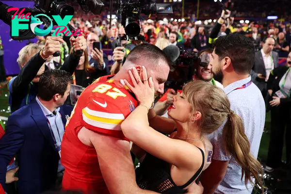 taylor swift holding onto travis kelce's face