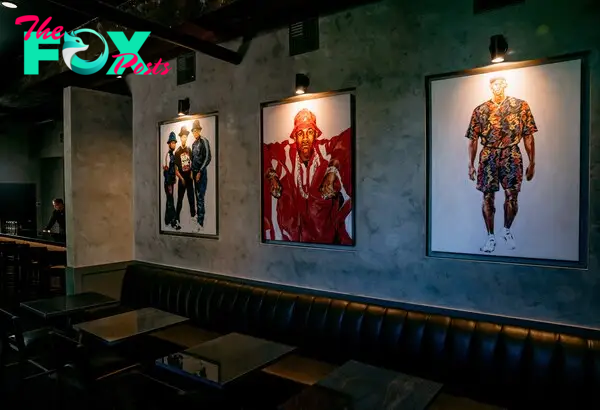 three paintings of rappers hanging on a wall