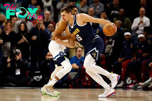 Nikola Jokic #15 of the Denver Nuggets drives to the basket while Karl-Anthony Towns #32 of the Minnesota Timberwolves defends
