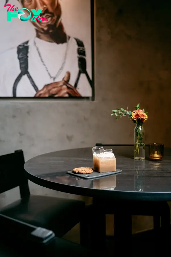 a corner table with a portrait of tupac hanging above it