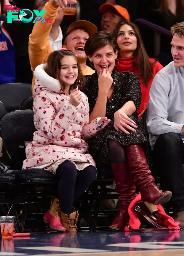 katie holmes and suri cruise sitting sideline at a basketball game