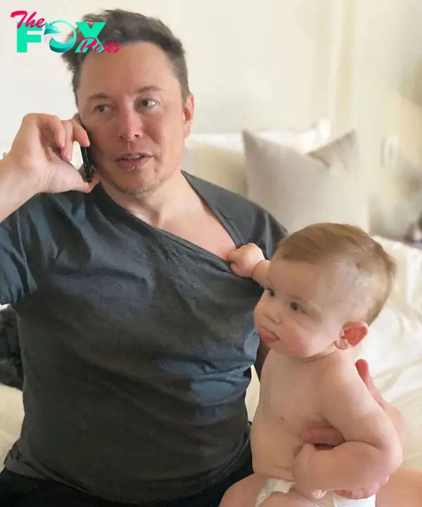 Elon Musk on a call with a a baby beside him.