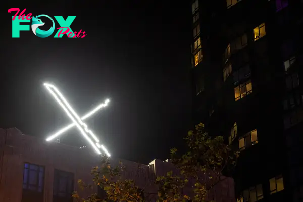 'X' logo is seen on the top of the messaging platform X, formerly known as Twitter