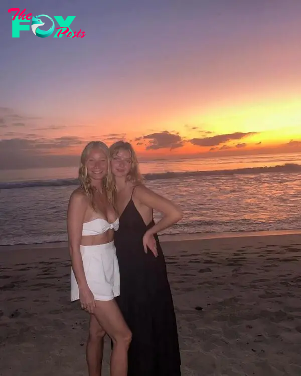 Gwyneth Paltrow and daughter Apple smiling on a beach at sunset