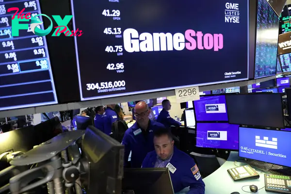 Traders work under signage for GameStop Corp. (NYSE: GME) on the trading floor at the New York Stock Exchange (NYSE) in Manhattan, New York City