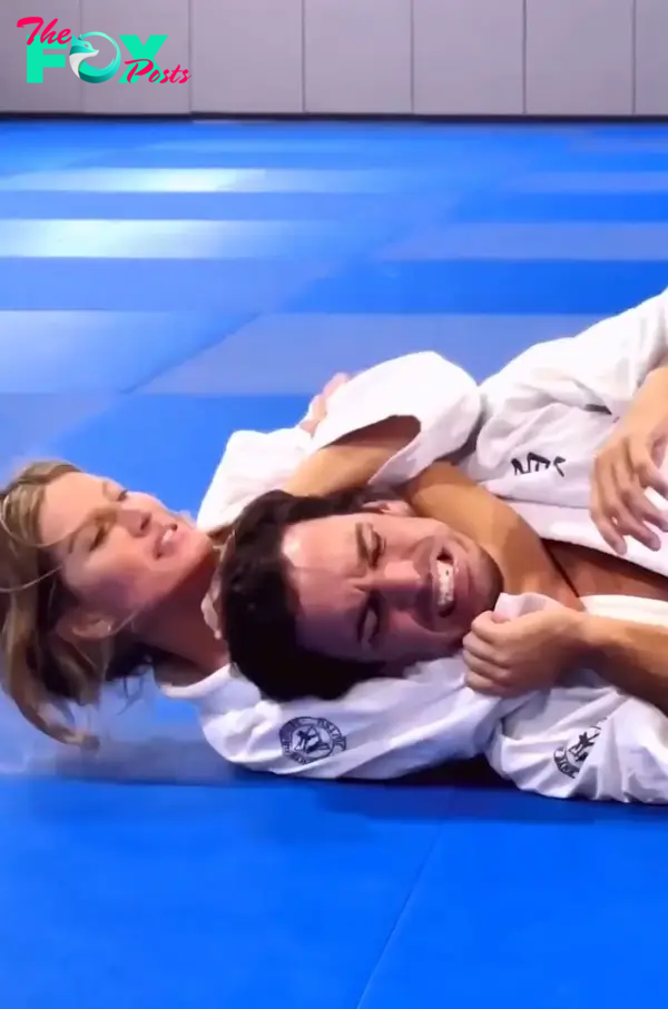 Gisele Bündchen and Joaquim Valente wrestling.