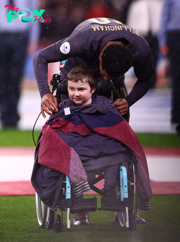 Touching moment as England star Bellingham gives his tracksuit top to mascot in wheelchair as it rains at Wembley | The Sun