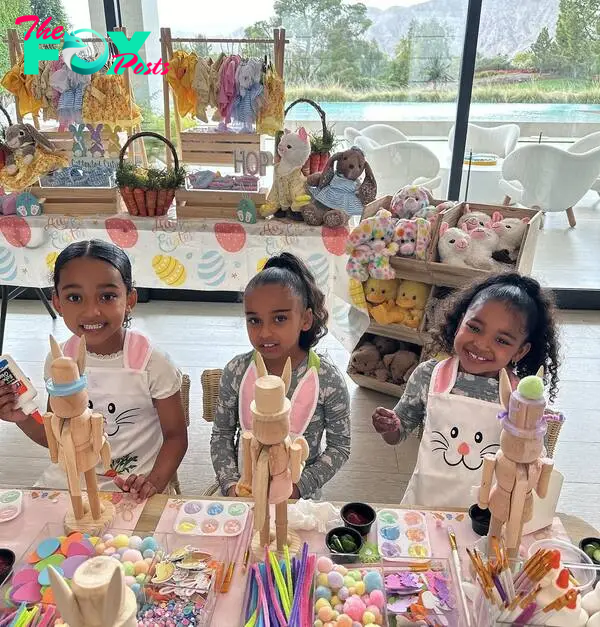 Three of the Kardashian children decorating a wooden toy soldier on Easter