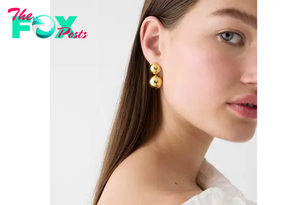 A model in gold  drop earrings