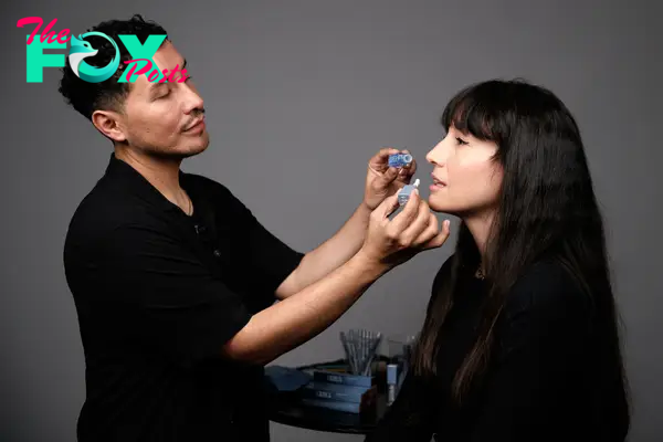 A makeup artist applying a lip oil