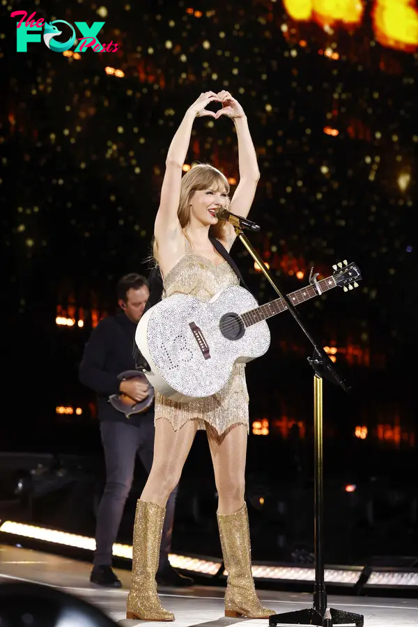Taylor Swift onstage making a heart with her hands.