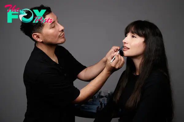 A makeup artist applying lip liner