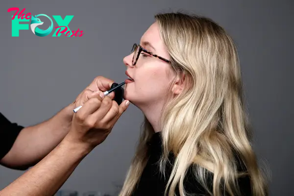 A makeup artist applying a lip liner