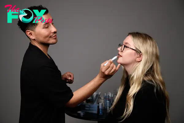 A makeup artist applying lipstick