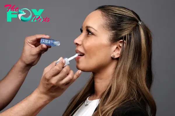 A makeup artist applying a lip oil