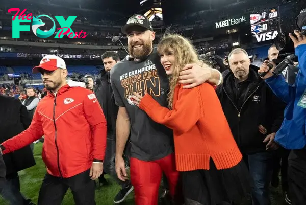 Taylor Swift and Travis Kelce on the football field. 