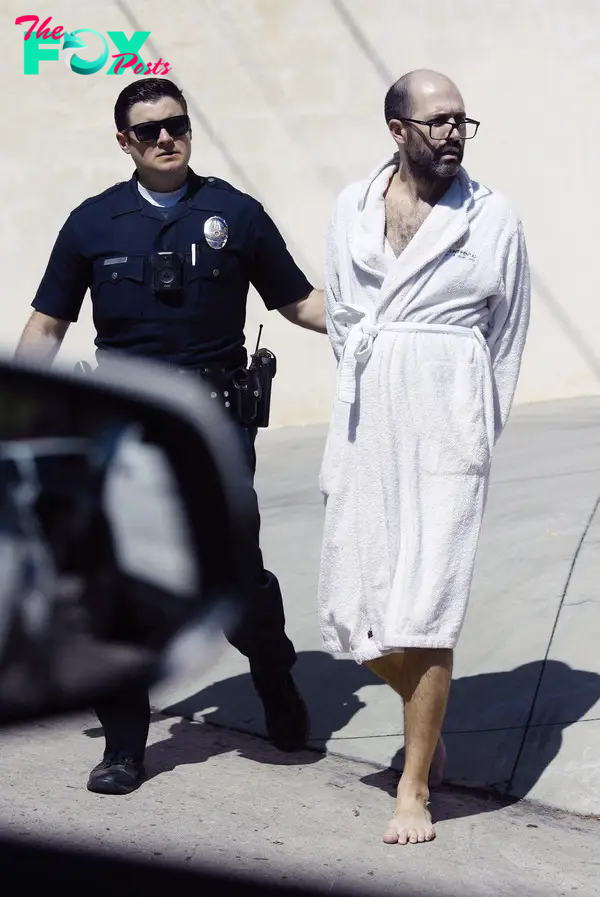Christian Richard being arrested in a robe.