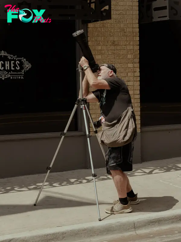A man watches photographs the solar eclipse in Dallas, Texas.