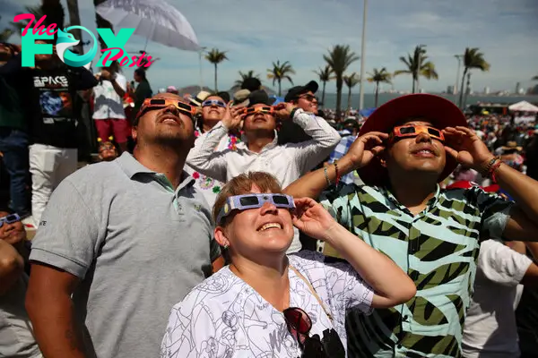People use special protective glasses to observe a total solar eclipse in Mazatlan, Mexico.