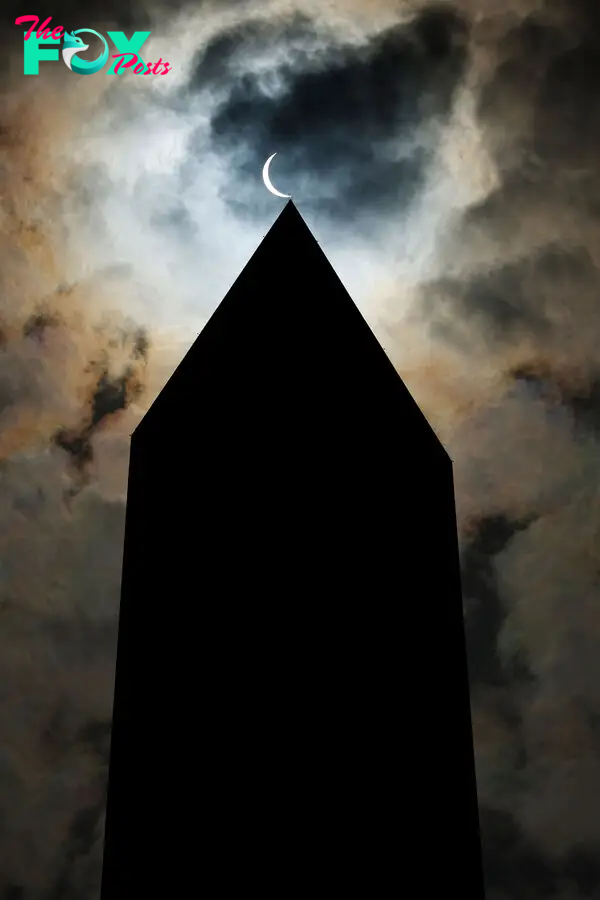 The solar eclipse is seen above the Washington Monument in Washington, D.C.