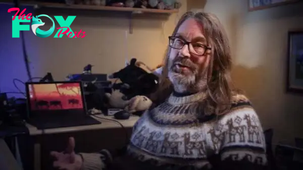 Jeff Minter wearing a jumper and talking to the camera in Llamasoft: The Jeff Minter Story.