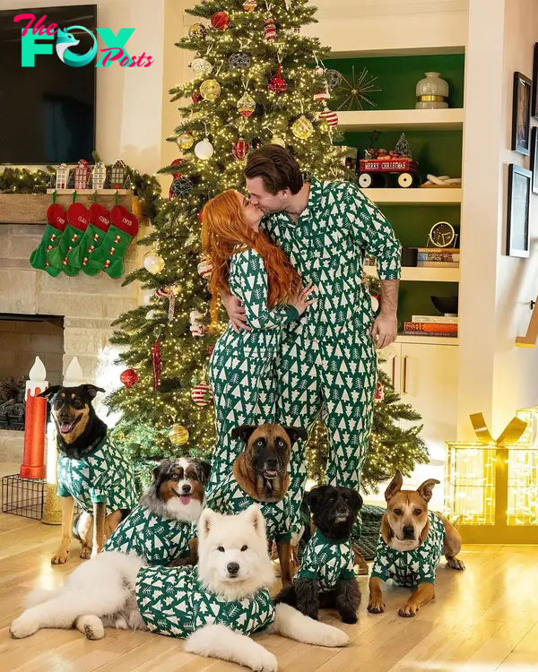 ariel winter, luke benward and their dogs in matching pajamas in front of a christmas tree