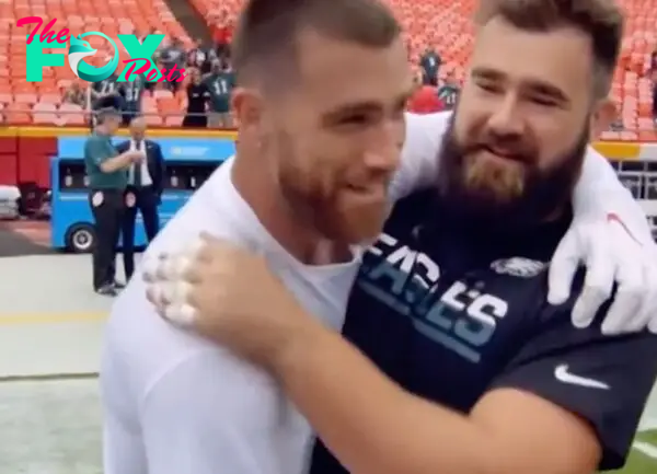 Travis and Jason Kelce  hugging on the football field. 