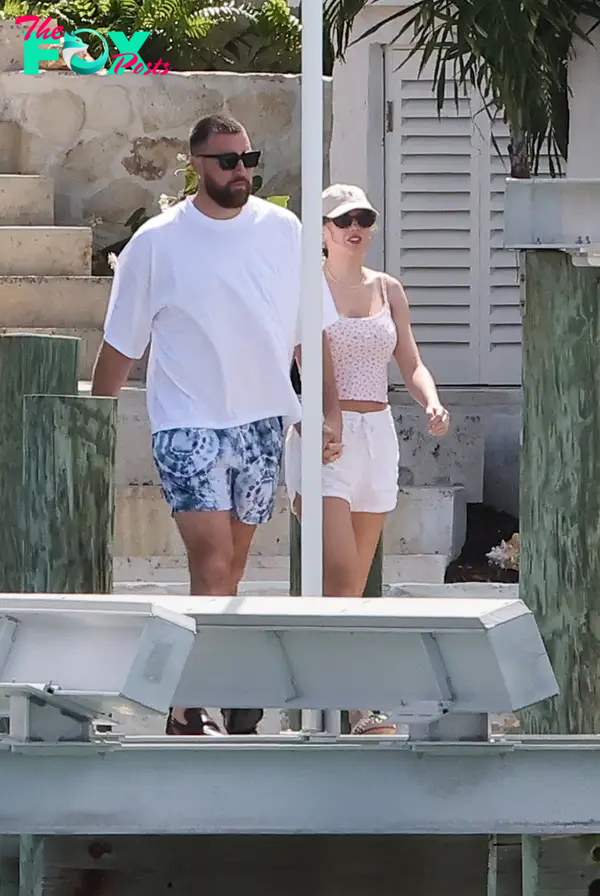 Taylor Swift and Travis Kelce holding hands in the Bahamas.