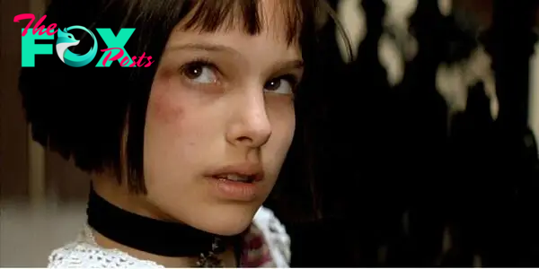 Natalie Portman as Mathilda wearing a necklace looking up at someone off-screen in Leon: The Professional