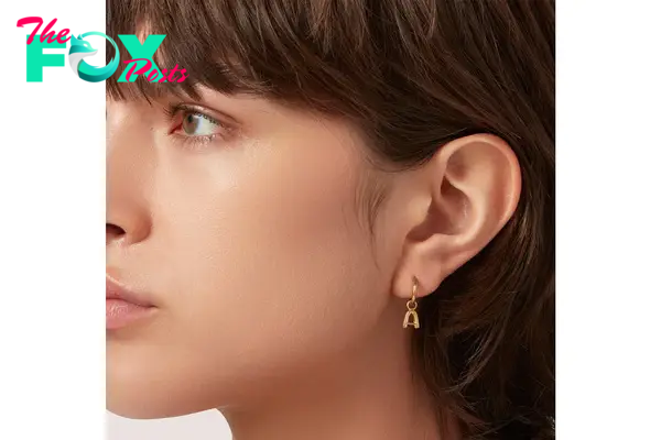 A model in an "A" huggie earring