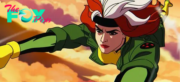 Rogue flies through colorful clouds, her hair streaming and a determined look on her face in X-Men ’97. 