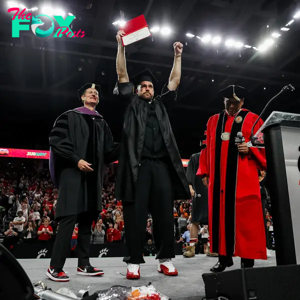 travis kelce holding up his college degree