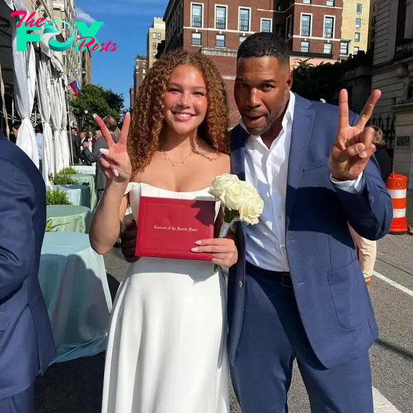 Isabella strahan holding up her high school diploma next to her father, michael strahan.