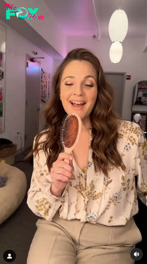Drew Barrymore talking into a hair brush