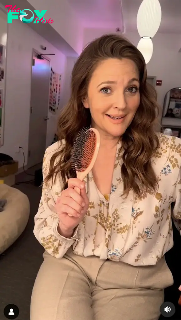 Drew Barrymore talking into a hair brush.