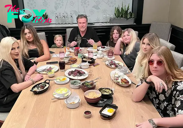 tori spelling, dean mcdermott and their kids seated around a restaurant table