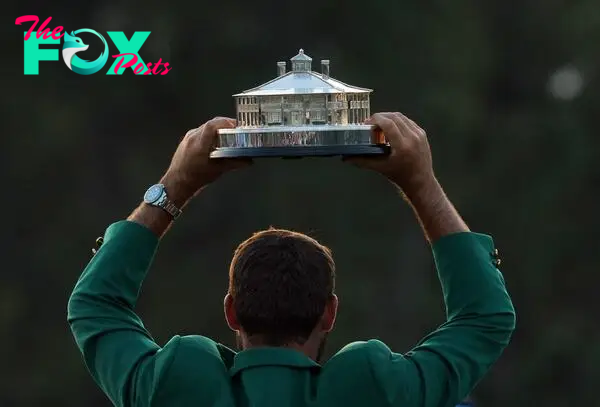 Scottie Scheffler of the U.S. celebrates with his green jacket and the trophy after winning The Masters.