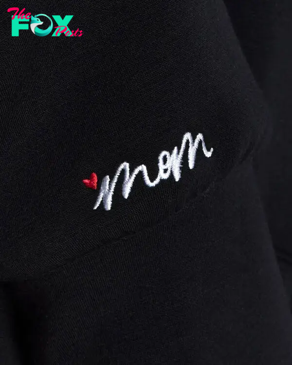 A close-up of "Mom" embroidery on a black sweatshirt
