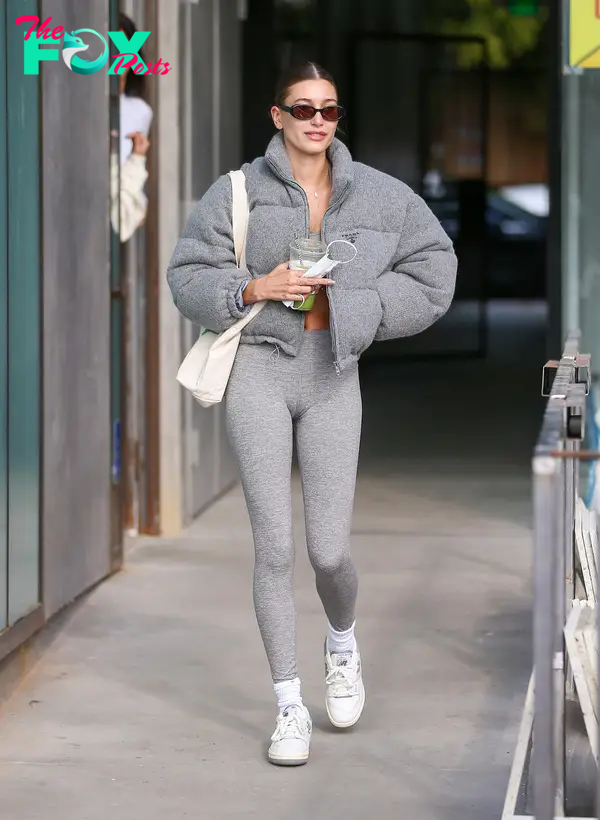 Hailey Bieber in Alo Yoga leggings and a gray puffer coat