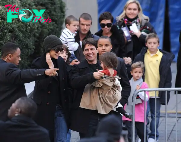 Tom Cruise holds Suri Cruise, with Katie Holmes next to him. Joined by Connor and Isabella Cruise. David Beckham holds Cruz Beckham, while Victoria Beckham holds hands with Brooklyn Beckham.