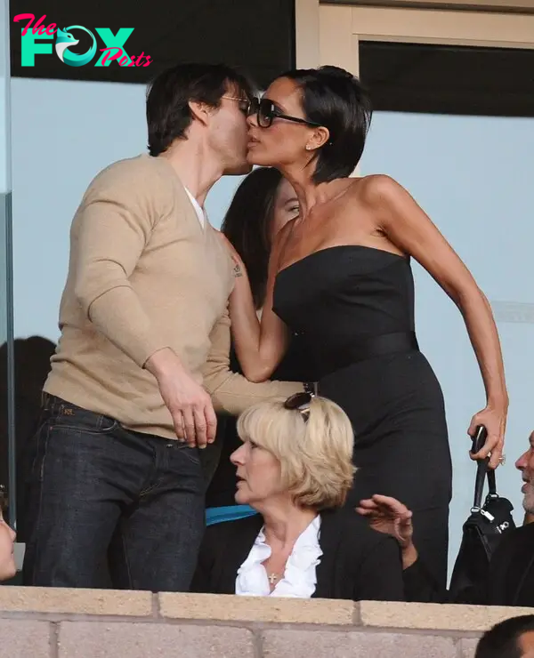 Tom Cruise kisses Victoria Beckham on the cheek.