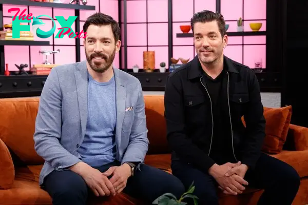 Drew and Jonathan Scott pose on a couch