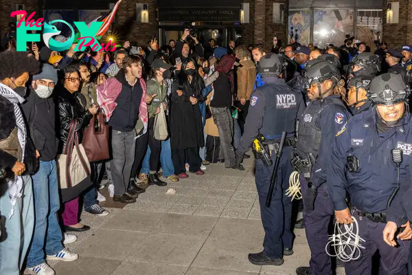 NYPD officers face protesters after detaining demonstrators and clearing an encampment set up by pro-Palestinian students and protesters on the campus of New York University, on April 22, 2024.