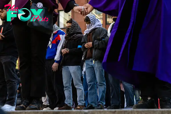 People pray as New York University students set up a tent encampment in Gould Plaza at NYU Stern School of Business on April 22, 2024.