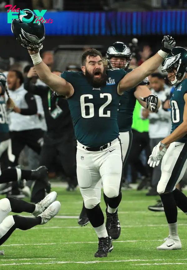 Jason Kelce running and cheering on a football field.