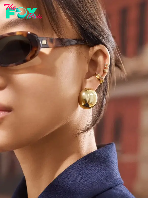 A model in a gold ball-shaped earring