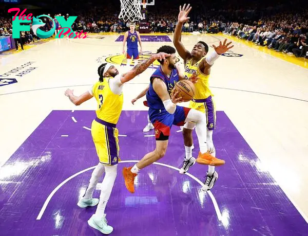 Jamal Murray #27 of the Denver Nuggets passes the ball against Anthony Davis #3 and Rui Hachimura #28 of the Los Angeles Lakers 