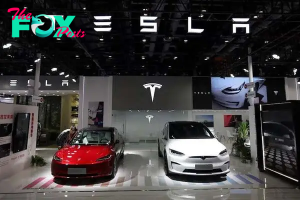 A staff member looks at Tesla's new Model 3 sedan displayed next to Model X SUV at the China International Fair for Trade in Services (CIFTIS) in Beijing, China September 2, 2023. PHOTO: REUTERS